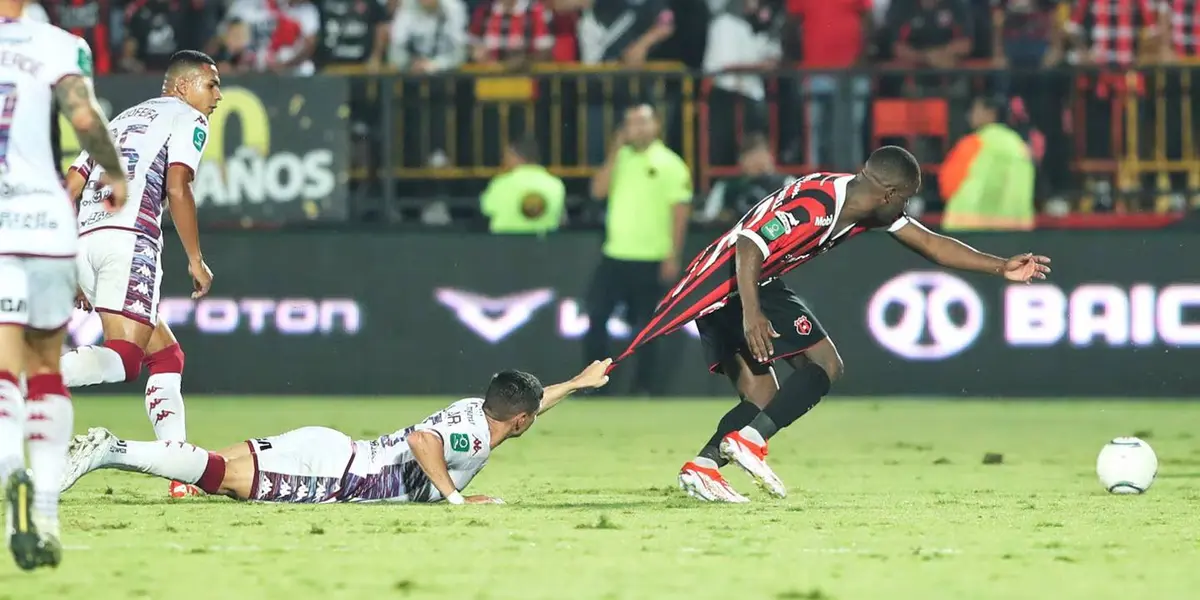 Joel Campbell mientras Joseph Mora le sujeta la camiseta. Foto: La Nación.